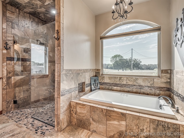 bathroom featuring a notable chandelier, a healthy amount of sunlight, and plus walk in shower