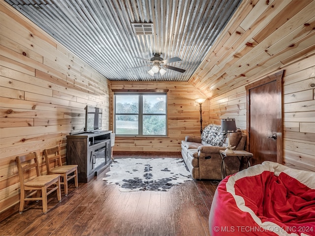 interior space featuring vaulted ceiling, wood walls, dark hardwood / wood-style flooring, and ceiling fan