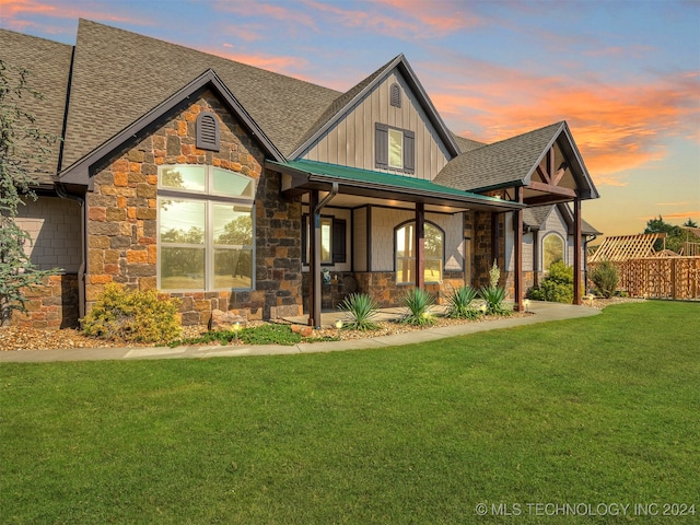 view of front of house featuring covered porch and a lawn