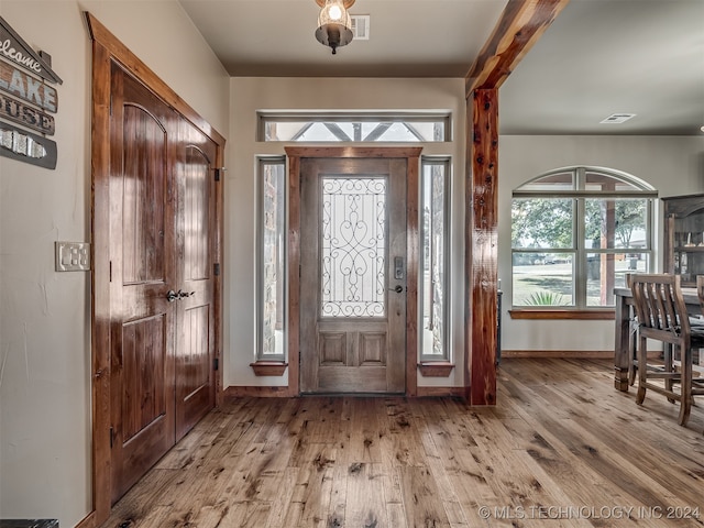 foyer entrance featuring beamed ceiling and light wood-type flooring