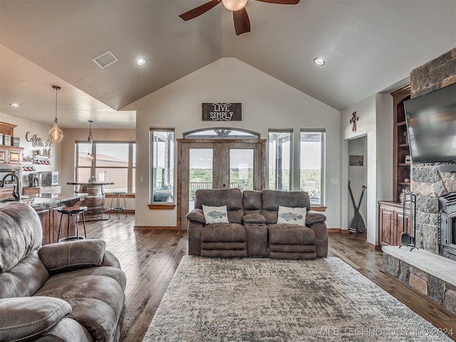 living room featuring dark wood-type flooring, high vaulted ceiling, french doors, and ceiling fan