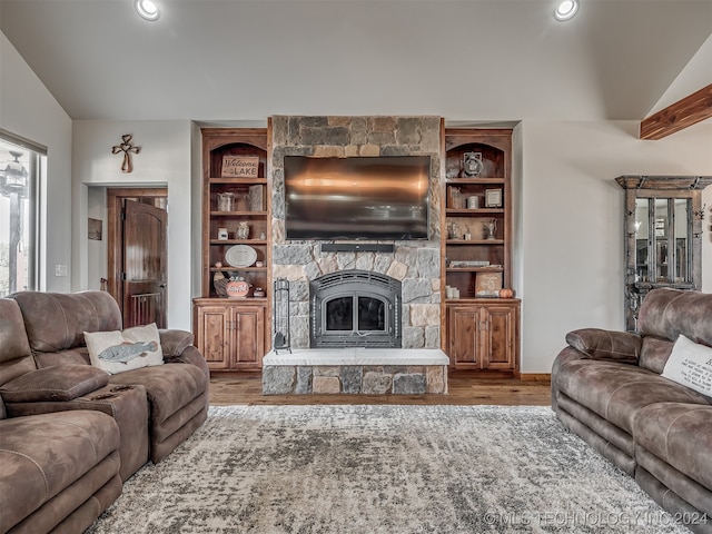 living room featuring vaulted ceiling, a fireplace, and wood-type flooring