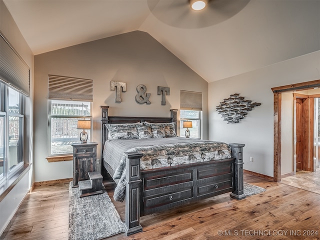 bedroom with light hardwood / wood-style floors, high vaulted ceiling, and ceiling fan