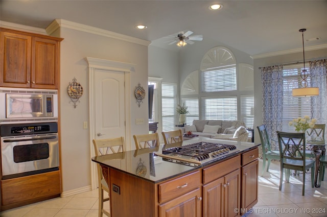 kitchen featuring a kitchen island, a breakfast bar, crown molding, appliances with stainless steel finishes, and light tile patterned floors