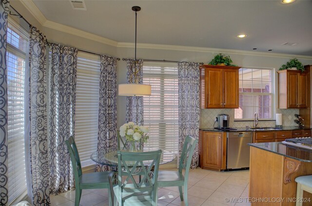 kitchen featuring tasteful backsplash, dishwasher, pendant lighting, light tile patterned flooring, and crown molding