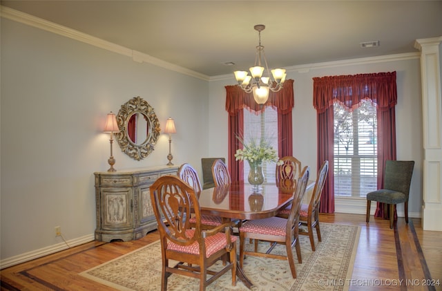 dining space featuring an inviting chandelier, ornamental molding, and hardwood / wood-style floors