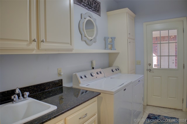 washroom with light tile patterned floors, sink, washing machine and clothes dryer, and cabinets