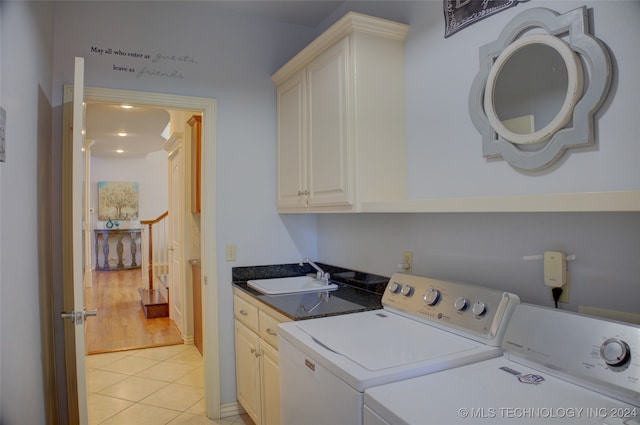 clothes washing area featuring cabinets, sink, separate washer and dryer, and light tile patterned flooring