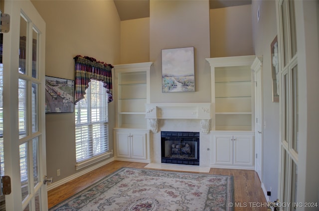 living room with built in shelves and hardwood / wood-style floors