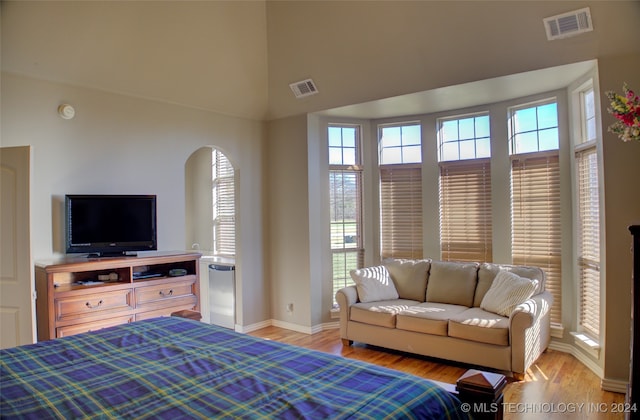 bedroom with high vaulted ceiling and light hardwood / wood-style flooring