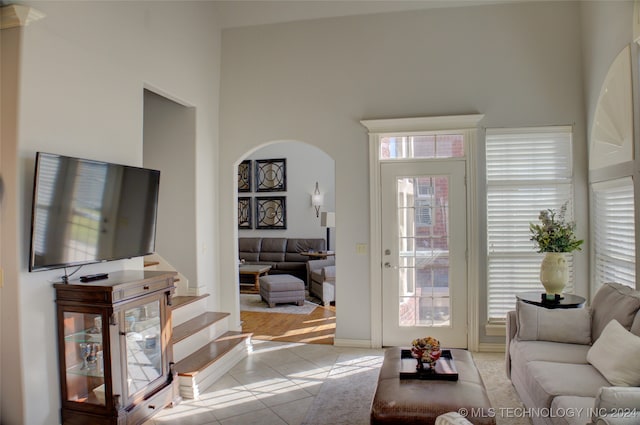 living room with light tile patterned flooring and a high ceiling