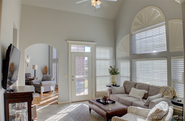 tiled living room featuring high vaulted ceiling and ceiling fan