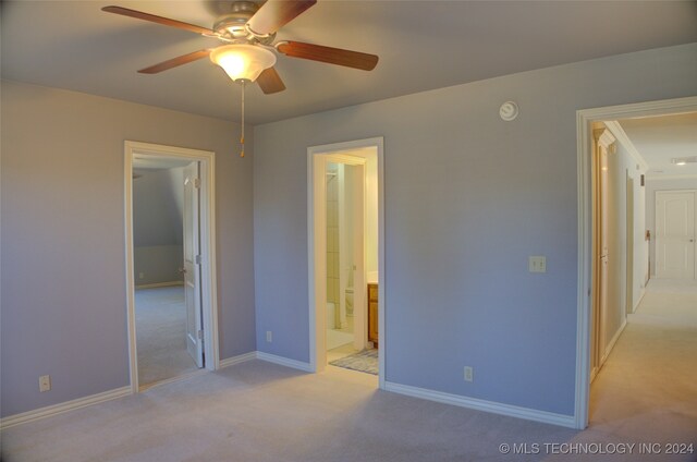 unfurnished bedroom with light carpet, ceiling fan, and connected bathroom