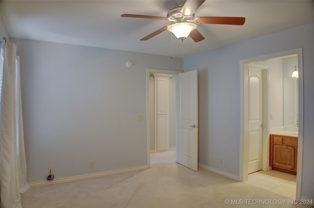 unfurnished bedroom featuring ensuite bath, ceiling fan, and light carpet