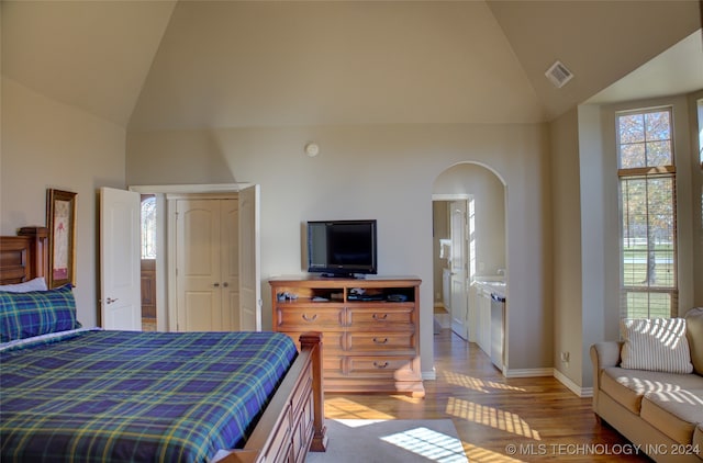 bedroom featuring high vaulted ceiling and light hardwood / wood-style floors