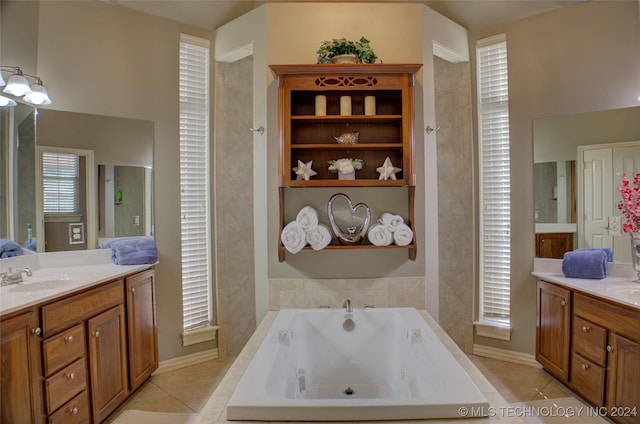 bathroom featuring tile patterned flooring, tiled tub, and vanity