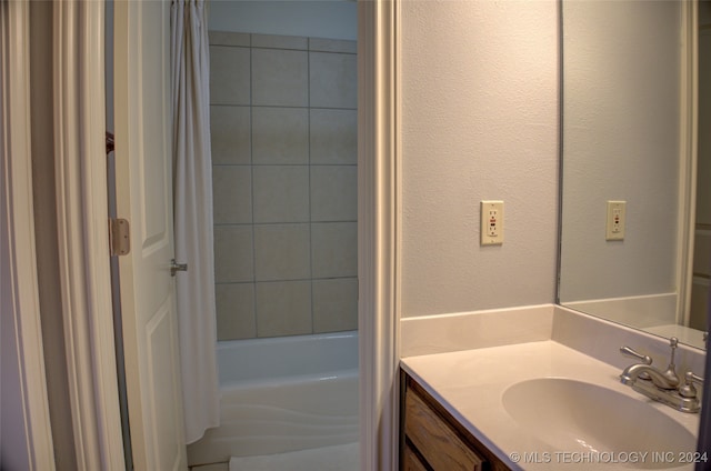 bathroom featuring shower / bath combo with shower curtain and vanity