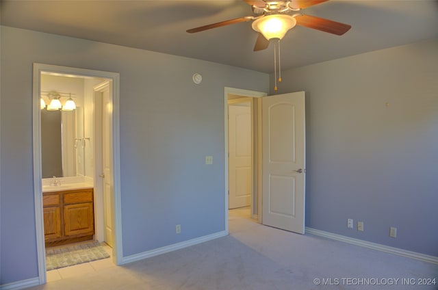 unfurnished bedroom with ensuite bathroom, light colored carpet, ceiling fan, and sink