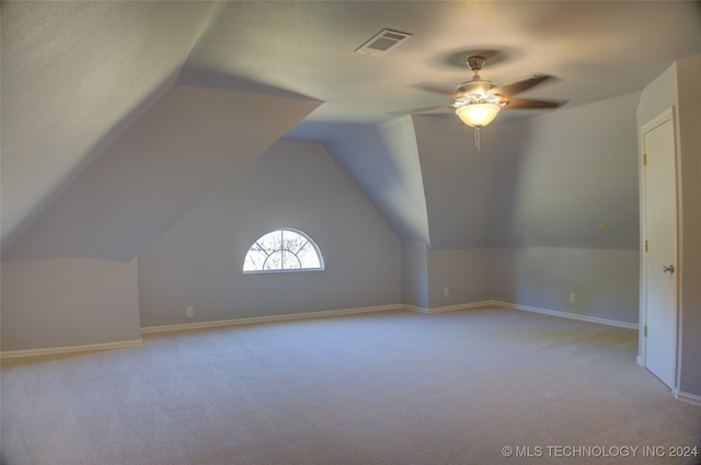 additional living space featuring ceiling fan, lofted ceiling, and light colored carpet