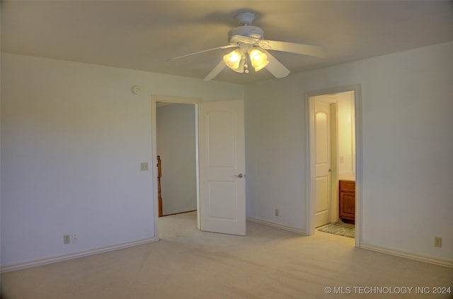 unfurnished bedroom with ceiling fan, connected bathroom, and light colored carpet