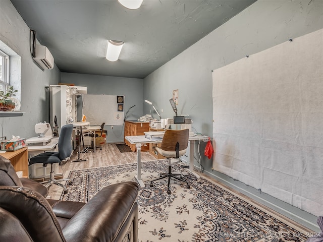 office featuring a wall mounted AC and light wood-type flooring