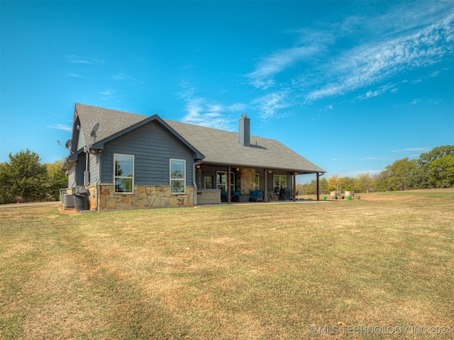 back of property featuring a yard, cooling unit, and a patio area