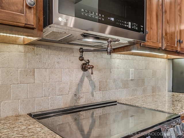 kitchen with light stone countertops and black range oven