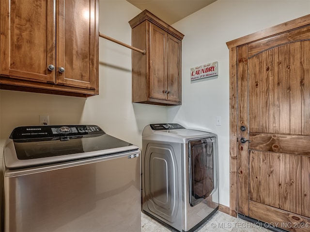 laundry area with cabinets and washer and clothes dryer