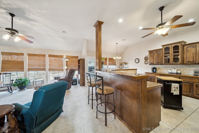 kitchen featuring vaulted ceiling, a center island, a breakfast bar area, and backsplash