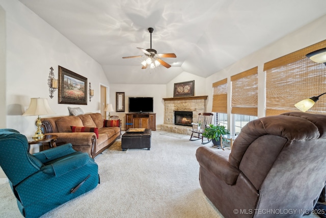 living room featuring lofted ceiling, a fireplace, light colored carpet, and ceiling fan