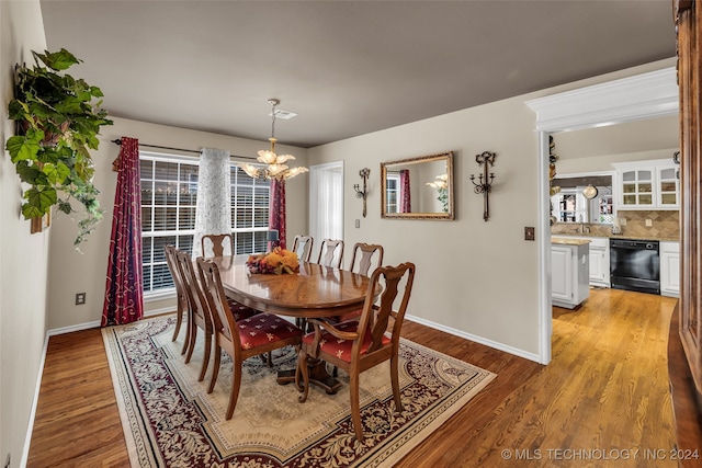 dining area featuring light wood-type flooring and an inviting chandelier