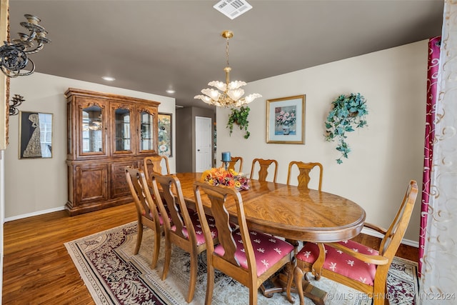 dining space with dark hardwood / wood-style flooring and a chandelier