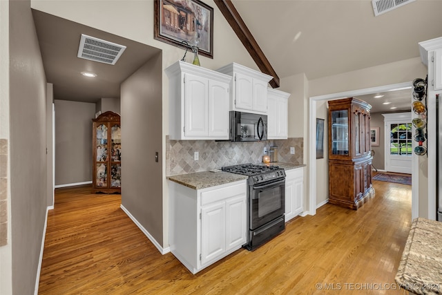 kitchen with black appliances, decorative backsplash, light wood-type flooring, light stone counters, and white cabinetry