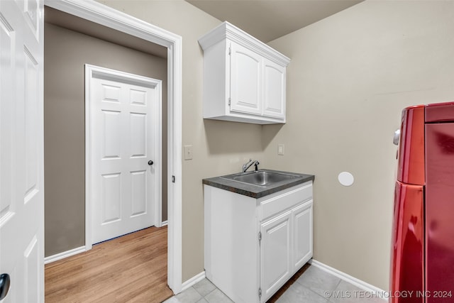 laundry area featuring light hardwood / wood-style floors and sink