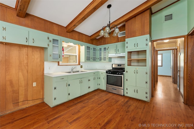 kitchen featuring sink, hanging light fixtures, stainless steel range with gas cooktop, beam ceiling, and hardwood / wood-style flooring