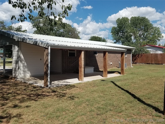 rear view of house with a patio area and a lawn