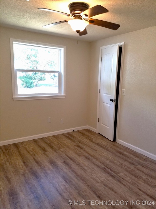 empty room with hardwood / wood-style floors, a textured ceiling, and ceiling fan