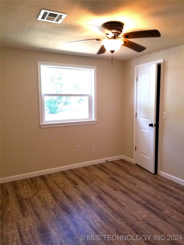 unfurnished room featuring dark wood-type flooring, ceiling fan, and a textured ceiling