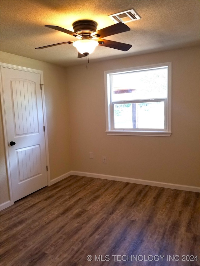 unfurnished room with dark wood-type flooring, ceiling fan, and a textured ceiling