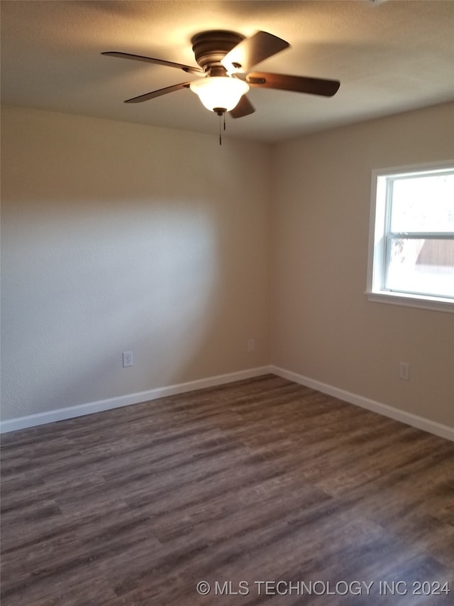 unfurnished room with dark wood-type flooring and ceiling fan