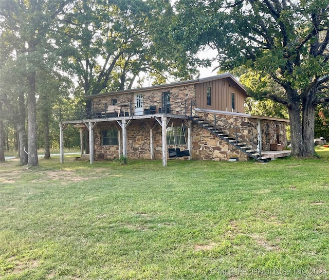 exterior space with stone siding, a wooden deck, stairs, and a front yard