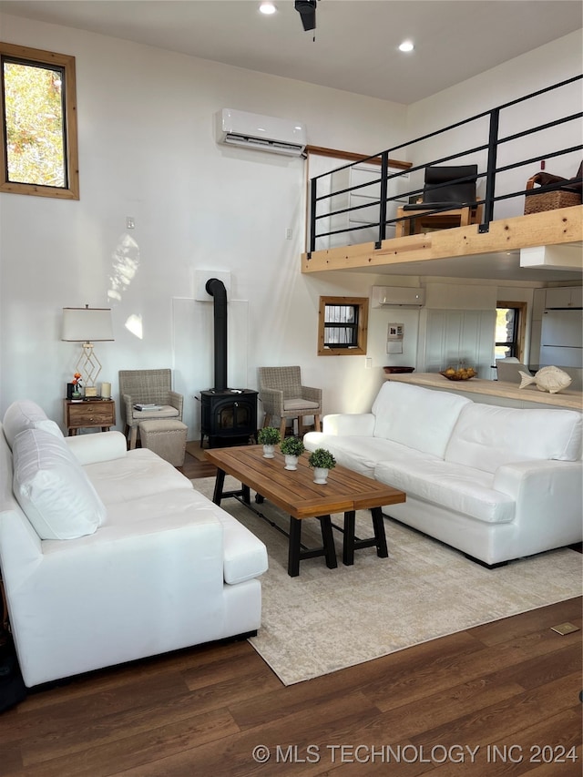 living room with a wood stove, recessed lighting, wood finished floors, and a wall mounted AC