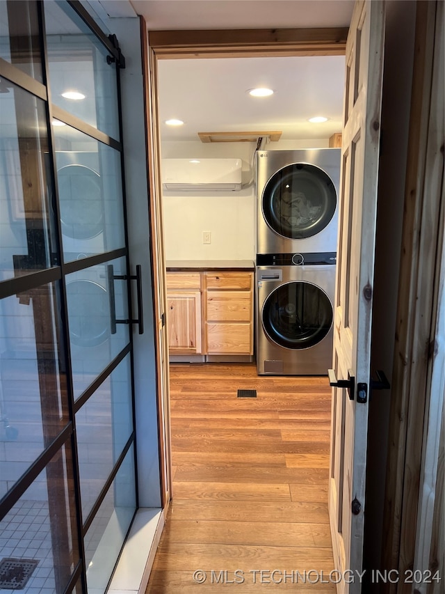 washroom featuring light hardwood / wood-style flooring and stacked washer / drying machine