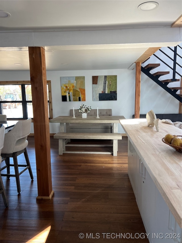 dining space featuring stairs and dark wood-style floors