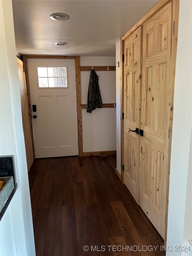 doorway to outside featuring dark wood finished floors and baseboards