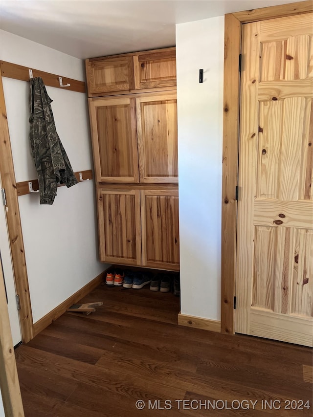 hall with baseboards and wood finished floors