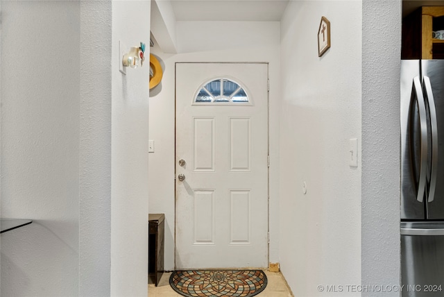 doorway to outside with light tile patterned floors