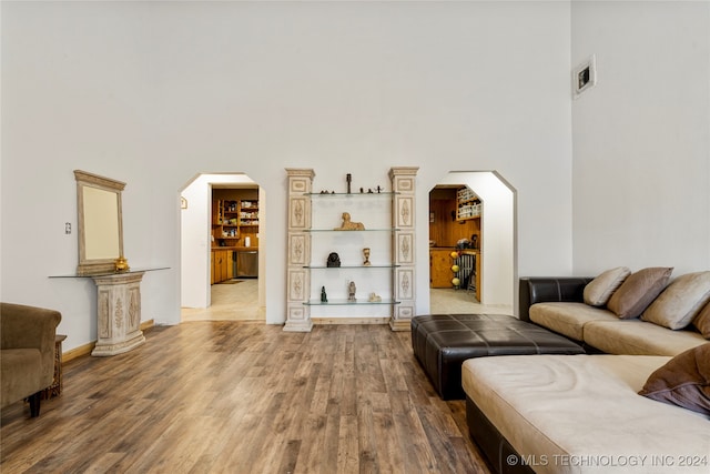 living room with wood-type flooring and a high ceiling