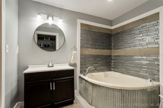 bathroom featuring vanity, tile patterned floors, a bathtub, and backsplash