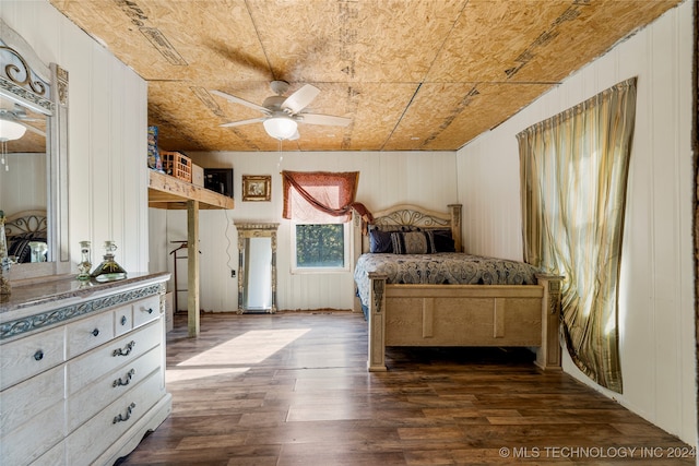 unfurnished bedroom with ceiling fan, hardwood / wood-style flooring, and wooden walls